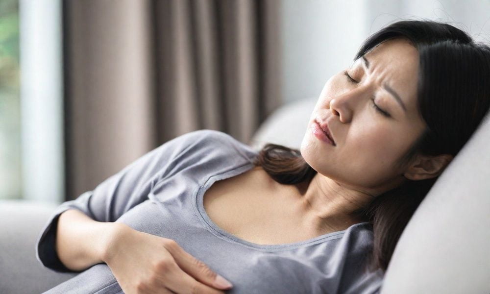 Cảm thấy đau, căng tức bụng là một trong những triệu chứng của táo bón liên quan đến u xơ tử cung